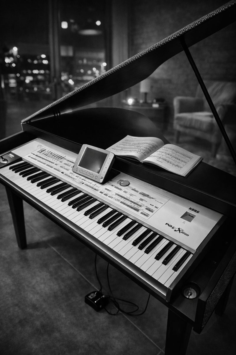 KeyGrand black skai piano shell with Korg Pa3X Pro keyboard in intimate evening setting, demonstrating real-world stage use